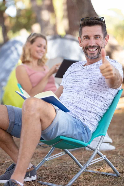 Par Läser Vid Sina Tält Man Håller Tummen Upp — Stockfoto