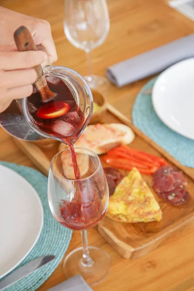 Woman pouring red sangria in the glass
