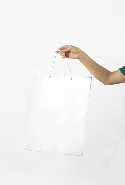 手与白色背景上的白纸袋 工作室拍摄 购物和消费主义概念 — 图库照片