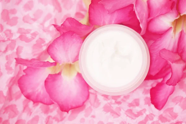 Face moisturizer cream on pink background, studio shot