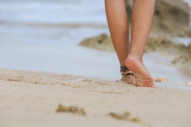 Kumsalda yürüyen bir kadın