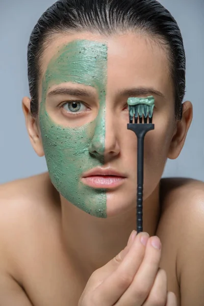 Jovem Mulher Tocando Máscara Facial Verde Retrato Estúdio — Fotografia de Stock