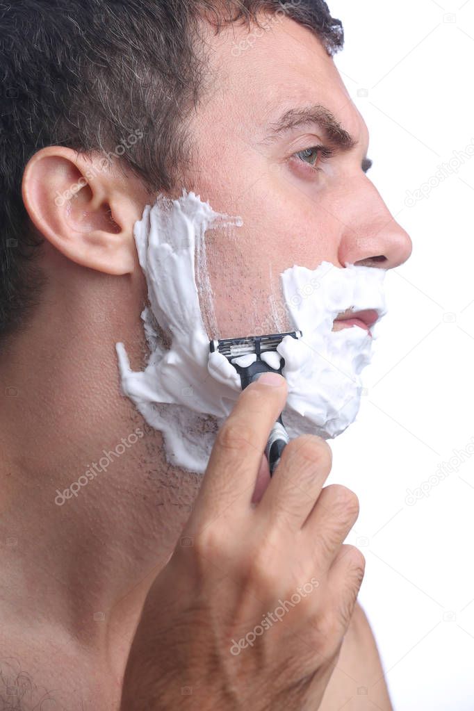 Young man shaving beard