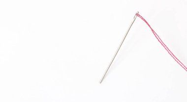 Beyaz arka plan ile kırmızı iplik dikiş iğnesi