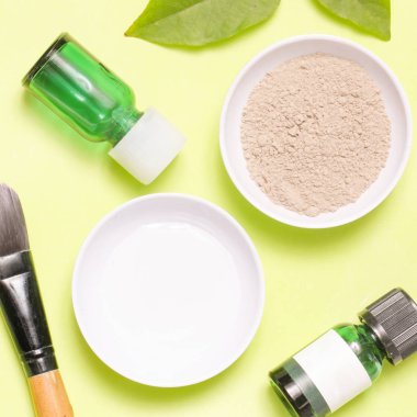 Sarı arka plan üzerinde farklı kozmetik ürünlerin üstten görünüm