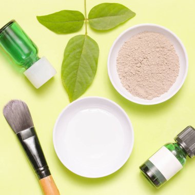 Sarı arka plan üzerinde farklı kozmetik ürünlerin üstten görünüm