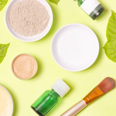 Sarı arka plan üzerinde farklı kozmetik ürünlerin üstten görünüm