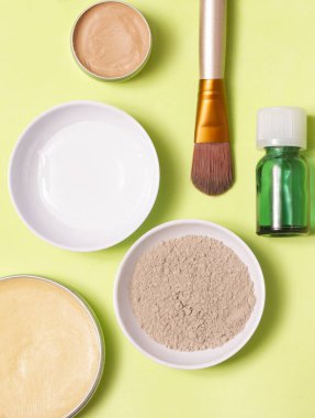 Sarı arka plan üzerinde farklı kozmetik ürünlerin üstten görünüm