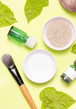 Sarı arka plan üzerinde farklı kozmetik ürünlerin üstten görünüm