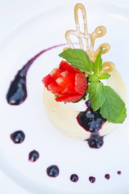 Tatlı şurubu ve çilekli krem karamel eşliğinde