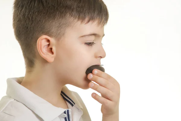 小男孩用巧克力糖果的工作室镜头 不健康的饮食习惯概念 — 图库照片