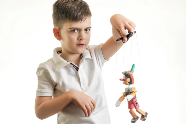 レトロな木製のピノキオおもちゃで遊ぶ少年のスタジオ撮影 — ストック写真