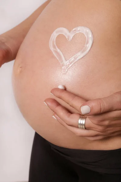 妊娠中の女性彼女の腹に保湿剤を適用する妊娠ストレッチ マークを防止します — ストック写真