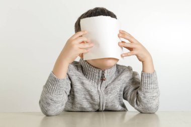 Stüdyo portre genç çocuğun beyaz boş kağıt tutan