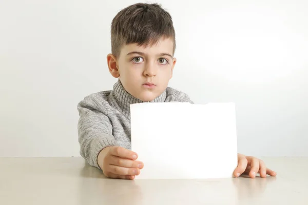 Estúdio Retrato Menino Segurando Papel Branco Branco — Fotografia de Stock