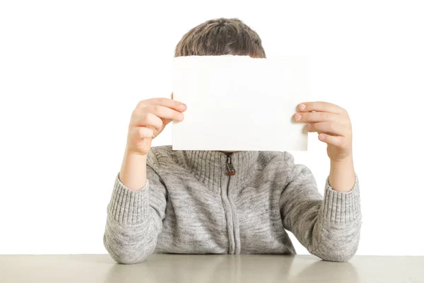 白い空白の紙を保持している若い男の子のスタジオ ポートレート — ストック写真