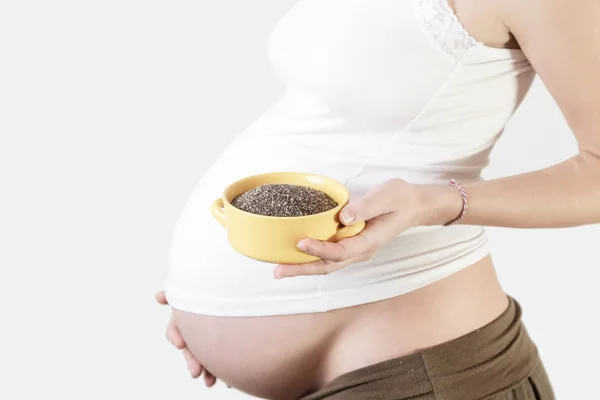 ボウル チアシードのスタジオ ショットを保持している妊娠中の女性 — ストック写真
