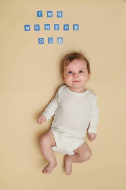 Çok güzel iki aylık bebek sarı arka planda, stüdyo vurdu