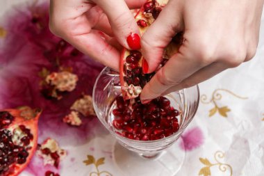 Pomegranate in hands - deseeding clipart