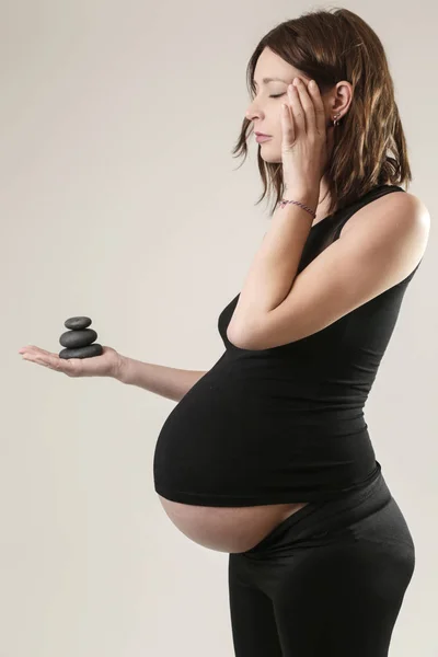 Kobieta Ciąży Holiding Czarny Zen Stones Relaks Koncepcja Równowagi — Zdjęcie stockowe
