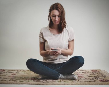 Akıllı telefonunu arayan genç kadın portresi stüdyo