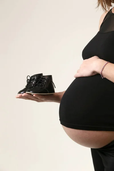 Zwangere Vrouw Houdt Van Schoenen Voor Haar Baby — Stockfoto