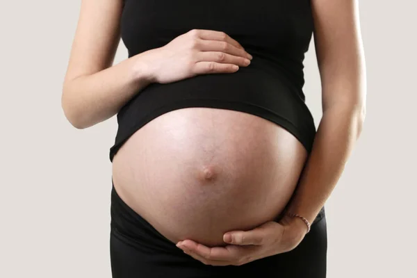 Kobieta Ciąży Trzymając Jej Brzuch Strzał Studio — Zdjęcie stockowe