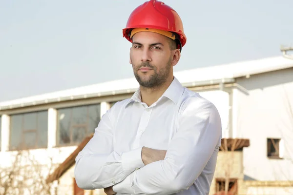 Outdoor portrait of serious attractive male wears a red helmet a — Stock Photo, Image