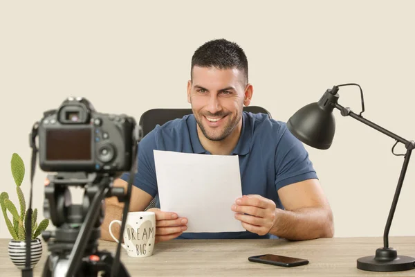 Młody uśmiechnięty wesoły człowiek siedzi w biurze biurowym w przedniej o — Zdjęcie stockowe