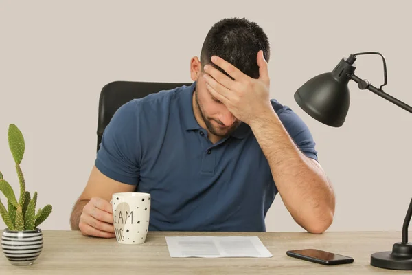 Jonge bezorgd man zittend aan het Bureau — Stockfoto