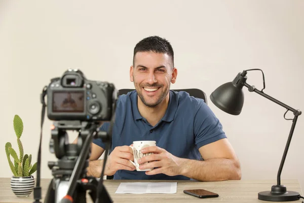 Unga leende glad man sitter vid kontors bordet framför o — Stockfoto