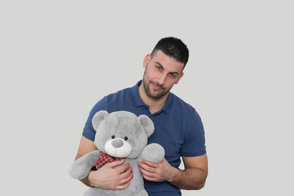 Portrait of a young handsome man holding a big teddy bear — Stock Photo, Image