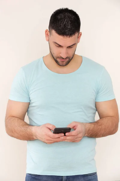 Portrait of a young man looking at his smartphone — Stock Photo, Image