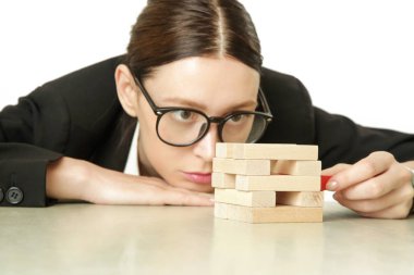 İş kadını oynarken Jenga oyunu, strateji, planlama ve risk kavramı.