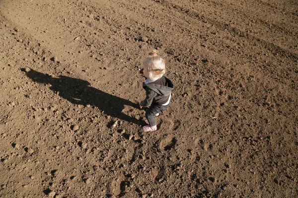 Bonito bebê menina brincando com a sujeira na parcela plana agrícola l — Fotografia de Stock