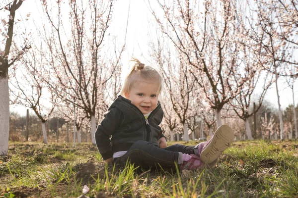 Baby girl enjoying a day in the blooming orchard, a weekend in t — Stock Photo, Image