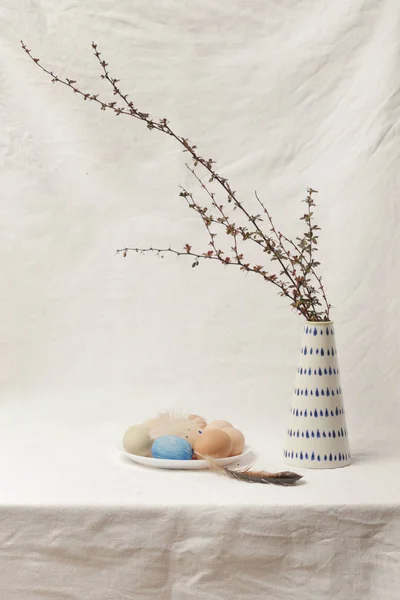 Pasen eieren op de tafel naast de keramische vaas met takken, — Stockfoto