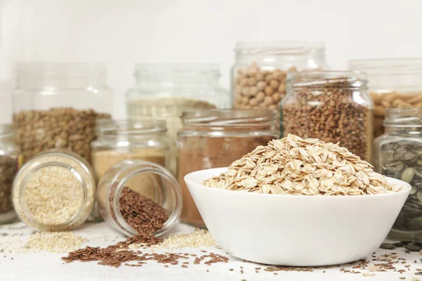 Tanti barattoli con cereali, semi, legumi, farine e vari alimenti — Foto Stock