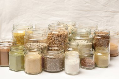 Tahıl, tohum, baklagiller, un ve çeşitli gıda maddeleri ile birçok kavanoz. Sağlıklı gıda kavramı.