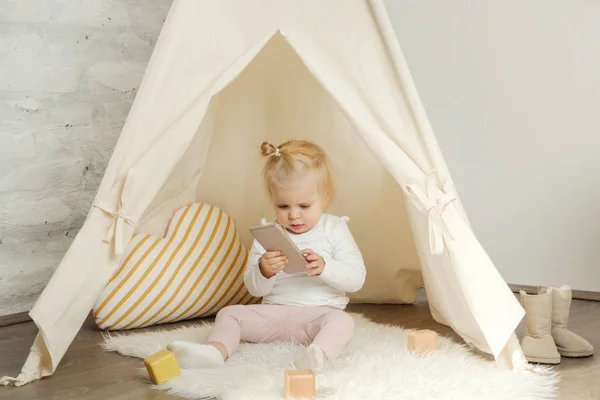 可爱的女婴在她的托儿所房间里玩智能手机 — 图库照片