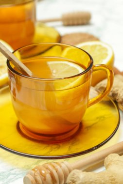 Sarı bir fincan çay, zencefil kökleri, limon ve baharatlar. Sağlıklı bir yaşam tarzı, Anti-grip ve anti-inflamatuar kavramı.