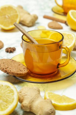 Sarı bir fincan çay, zencefil kökleri, limon ve baharatlar. Sağlıklı bir yaşam tarzı, Anti-grip ve anti-inflamatuar kavramı.