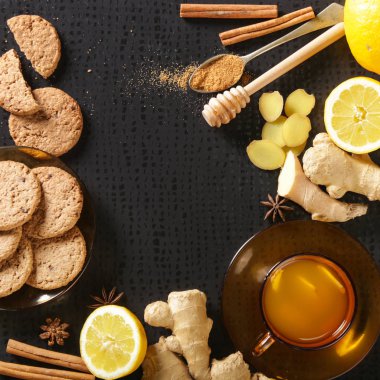 Karanlık arka planda zencefil kökleri ve limon ile bir bardak zencefil çayı. Sağlıklı bir yaşam tarzı, Anti-grip ve anti-inflamatuar kavramı.