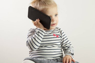 Bir cep telefonu tutan sevimli sarışın kız bebek Stüdyo portre