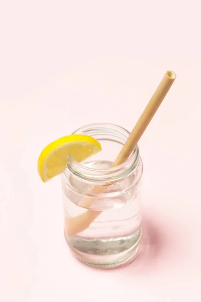 ピンクの背景にレモン水のガラスの竹ストロー 単一使用プラスチックストロー 健康的で持続可能なライフスタイルの概念のための代替として再利用可能な竹のストロー — ストック写真