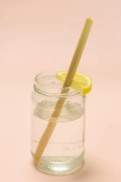 ピンクの背景にレモン水のガラスの竹ストロー 単一使用プラスチックストロー 健康的で持続可能なライフスタイルの概念のための代替として再利用可能な竹のストロー — ストック写真