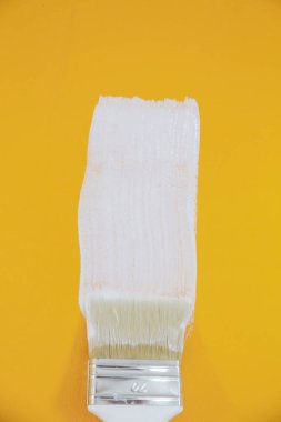 Sarı bir duvar üzerinde beyaz boya ile boyama 