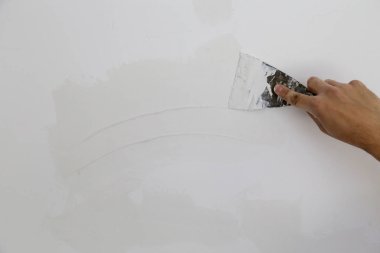 Macun bıçağı ile duvar sıva, görüntü yakın. Duvar yüzeyinin sabitlenmesi ve boyama için hazırlık.