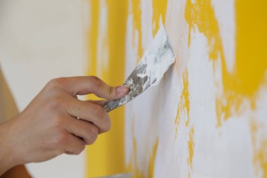 Macun bıçağı ile duvar sıva, görüntü yakın. Duvar yüzeyinin sabitlenmesi ve boyama için hazırlık.