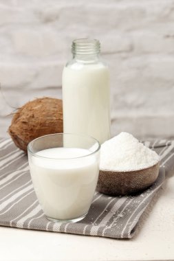 Hindistan cevizi sütü, hindistan cevizi gevreği ve taze kahverengi hindistan cevizi meyvesi. Organik vegan süt dışı süt bazlı süt.